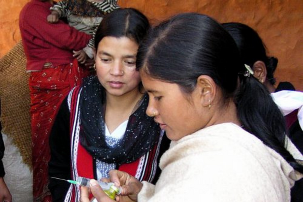 Two girls are looking at a piece of paper.