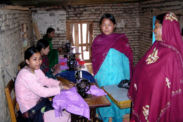 A group of women sewing clothes in a room.