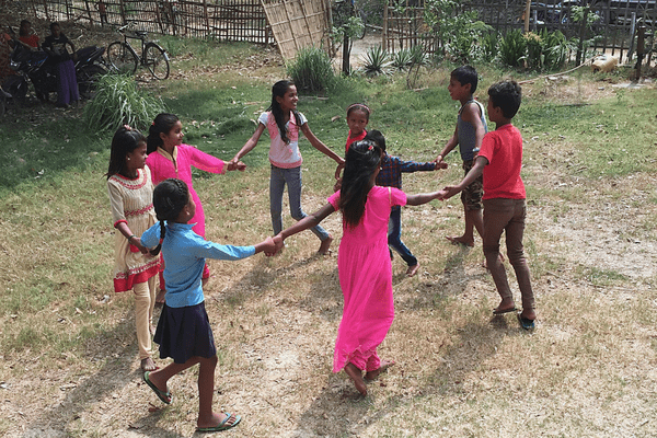 A group of children holding hands in the middle of a circle.