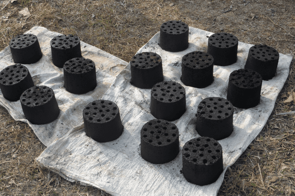 Round carbon bricks drying under the sun