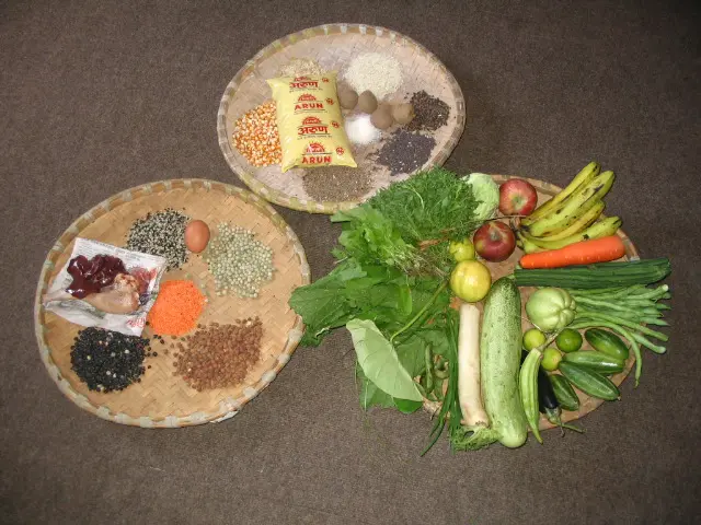 A bowl of vegetables and other foods on the floor.