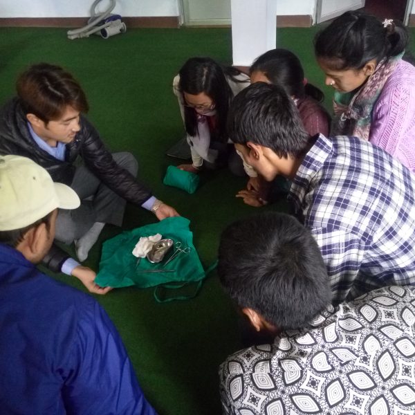 A group of people sitting on the ground playing with a toy.