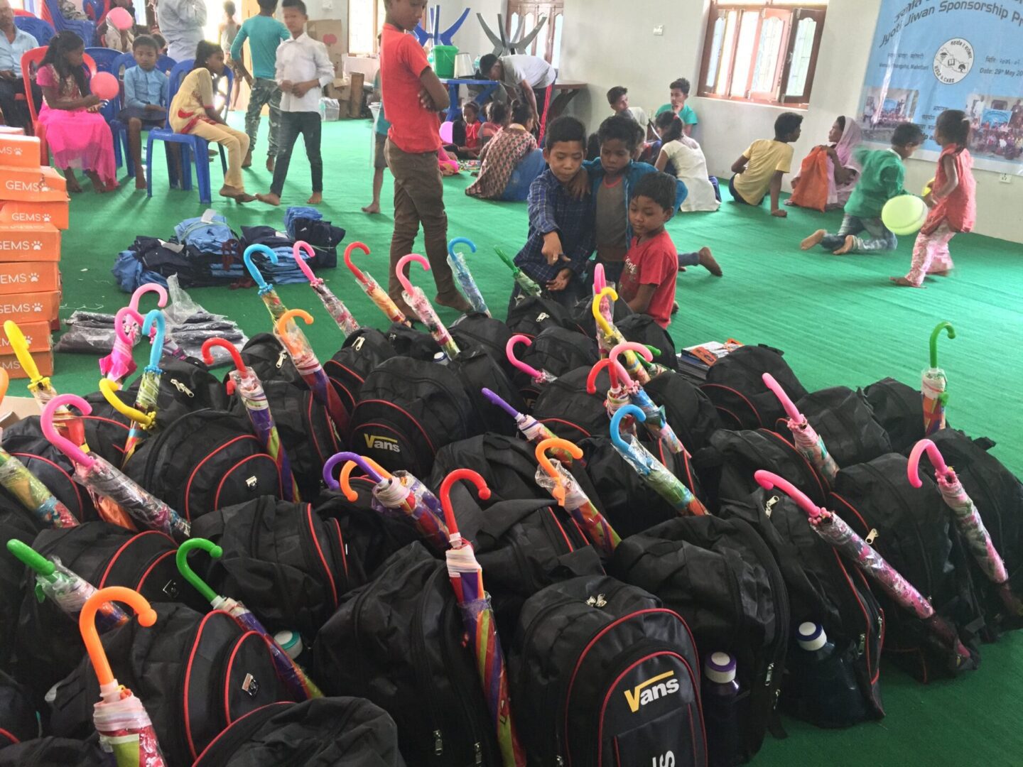 A group of children sitting around some backpacks