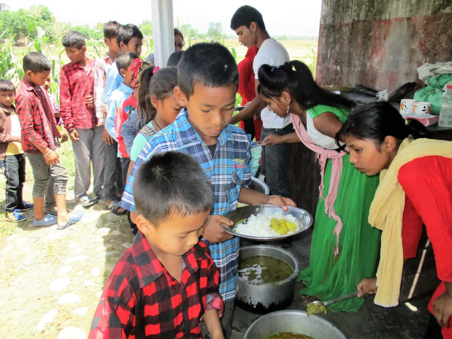 A group of children standing around a table.