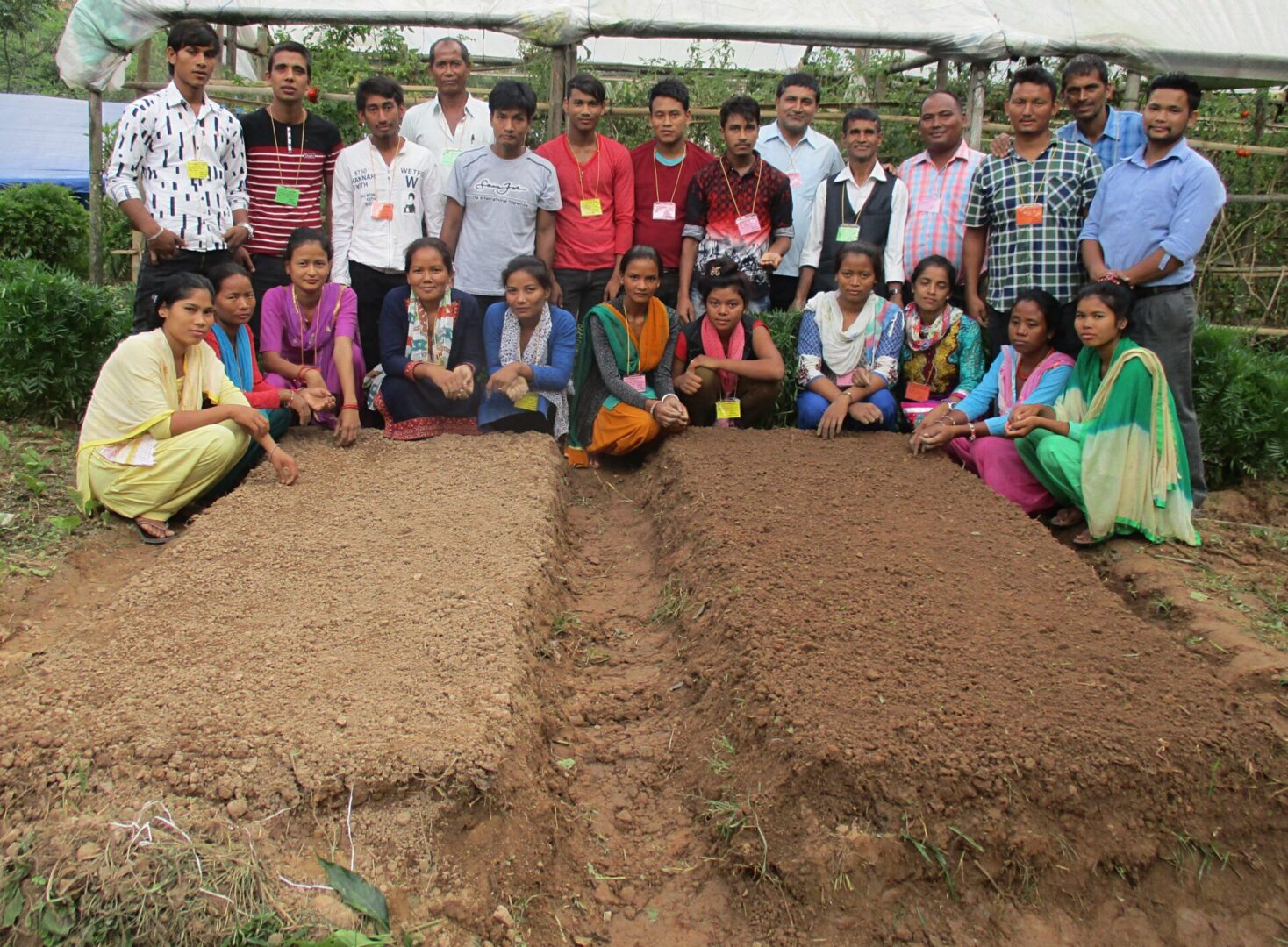 A group of people standing around in the dirt.