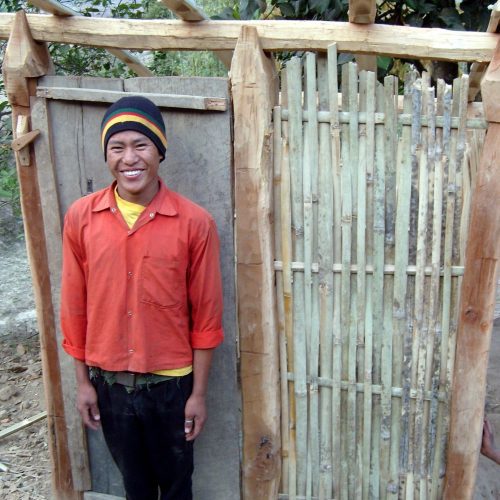 A man standing in front of a wooden door.